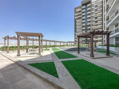 a patio with benches and picnic tables and grass at Modern Studio In Al-Furjan close to Metro-15 in Dubai