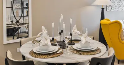 a dining room table with chairs and a yellow chair at Burj View 2BHK Downtown Infinity Pool in Dubai