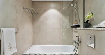 a bathroom with a shower and a bath tub at Burj View 2BHK Downtown Infinity Pool in Dubai