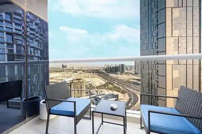 a balcony with chairs and a view of a city at PNB Living - Luxury 2 Bedroom Apartment with High Floor - DAMAC Towers by Paramount Tower D in Dubai