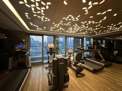a gym with a man running on tread machines in a building at PNB Living - Luxury 2 Bedroom Apartment with High Floor - DAMAC Towers by Paramount Tower D in Dubai