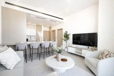 a white living room with a white couch and a table at Stylish 1BR at Binghatti Phantom with Private Pool in Dubai
