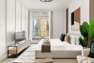 a white bedroom with a large bed and a window at Silkhaus Studio Stay in Dubai Marina - Botanica in Dubai