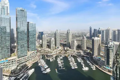 an aerial view of a city with boats in a harbor at LIV Marina, Dubai Marina - 4 Bedroom Penthouse with Panoramic Views - Allsopp & Allsopp in Dubai