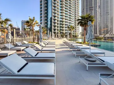 a row of chaise lounge chairs next to a pool at GuestReady - Premium Location | Studio | Pool View in Dubai