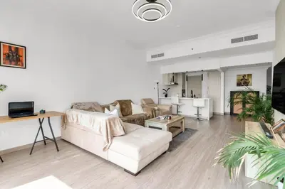 a living room with a couch and a table at Scenic Lakeview Stay Stylish 1 Bedroom in JLT in Dubai