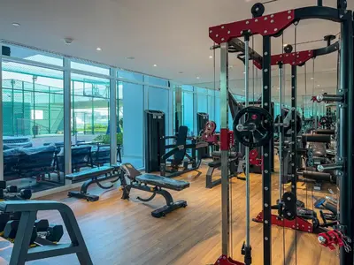 a gym with treadmills and machines in a building at Chic Studio near Dubai Miracle Garden & Expo City in Dubai