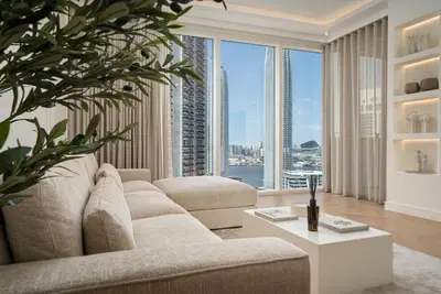 a living room with a couch and a large window at Daniels 2BR at Creek Gate with Canal View in Dubai