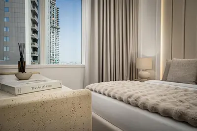 a white bedroom with a bed and a window at Daniels 2BR at Creek Gate with Canal View in Dubai