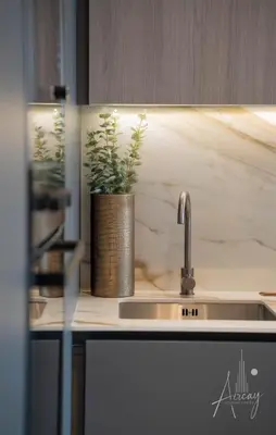 a kitchen sink with a potted plant on the counter at 1BR Sunlit Modern Retreat with Private Sunbeds in Dubai