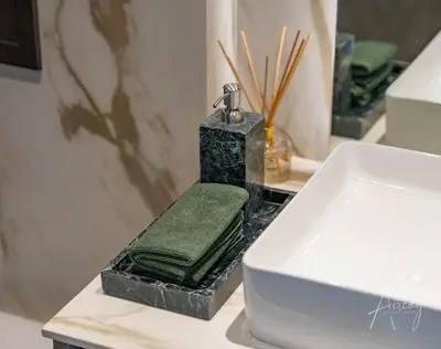 a bathroom sink with a green towel on a counter at 1BR Sunlit Modern Retreat with Private Sunbeds in Dubai