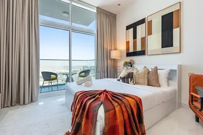 a bedroom with a bed and a large window at Peaceful High-Rise Studio Overlooking Miracle Garden, Skyz by Danube, Arjan by Deluxe Holiday Homes in Dubai