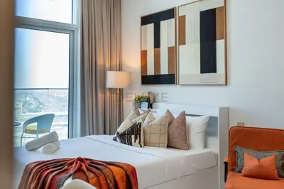 a bedroom with a bed with pillows and a window at Peaceful High-Rise Studio Overlooking Miracle Garden, Skyz by Danube, Arjan by Deluxe Holiday Homes in Dubai