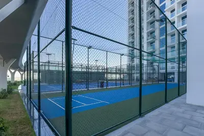 a tennis court behind a fence in a building at Peaceful High-Rise Studio Overlooking Miracle Garden, Skyz by Danube, Arjan by Deluxe Holiday Homes in Dubai
