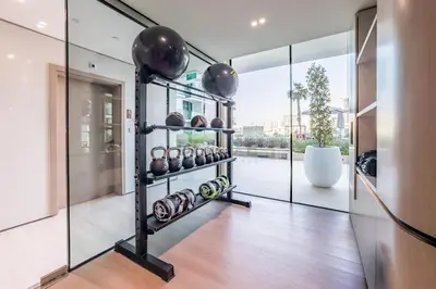 a gym with a rack of dumbbells in a house at Well-Appointed Studio, Minutes from Circle Mall and Community Parks - Binghatti Phoenix, Jumeirah Village Circle by Deluxe Holiday Homes in Dubai
