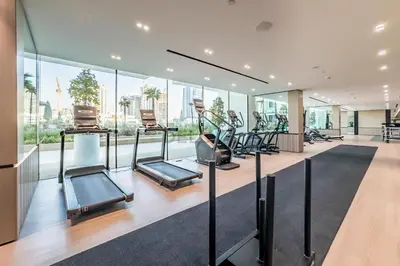 a gym with cardio equipment in a building at Well-Appointed Studio, Minutes from Circle Mall and Community Parks - Binghatti Phoenix, Jumeirah Village Circle by Deluxe Holiday Homes in Dubai