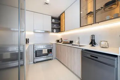 a kitchen with white cabinets and stainless steel appliances at Mahogany 26 - 4BR 9PAX - Dubai Hills Park Peaceful in Dubai
