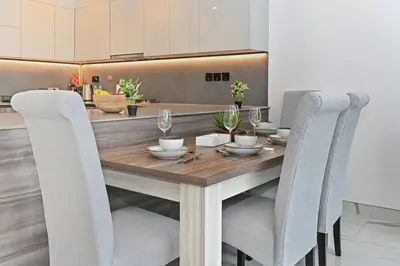 a dining room with a wooden table and chairs at Luxury 1BR at Royal Regency, Refined City Living in Dubai
