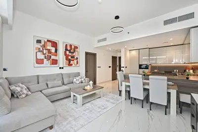 a living room with a couch and a table at Luxury 1BR at Royal Regency, Refined City Living in Dubai