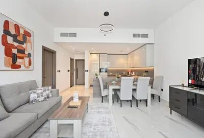 a living room with a couch and a table at Luxury 1BR at Royal Regency, Refined City Living in Dubai