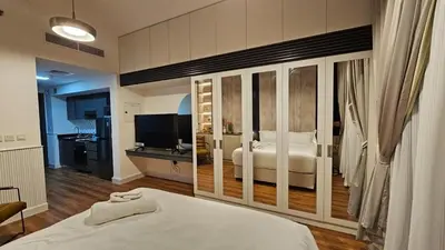 a bedroom with a white bed and a television at Bella-Rose-Fully Furnished Cozy High Floor Amazing View in Dubai