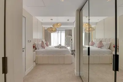 a bedroom with two beds and a mirror at Waves - JW Marriot Residence Modern & Chic 1BR Apt in Dubai