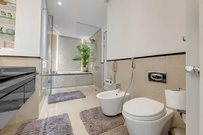 a white bathroom with a toilet and a sink at Waves - JW Marriot Residence Modern & Chic 1BR Apt in Dubai
