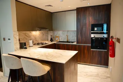 a kitchen with a counter and two bar stools at Italian-Design 2BR l Large Private Terrace l Ground Floor in Dubai