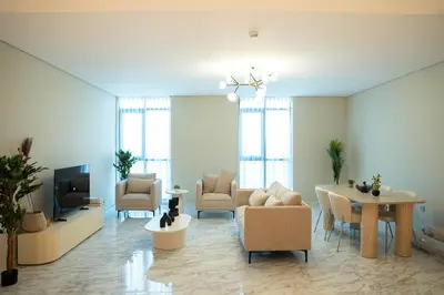 a living room with a table and chairs and a tv at Italian-Design 2BR l Large Private Terrace l Ground Floor in Dubai