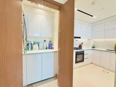 a kitchen with white cabinets and an open door at Elegant and Stylish Retreat - Lavender Binghatti 1103 in Dubai