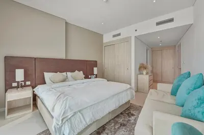 a large bedroom with a large bed and a couch at Luxury 2BR at Seven Palm Rooftop Pool&Beach Access in Dubai