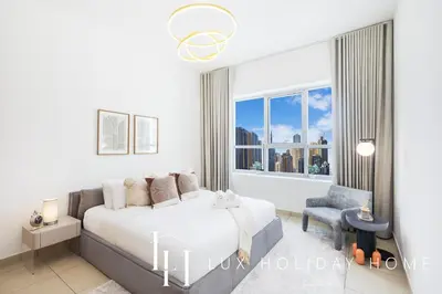 a bedroom with a bed and a window at LUX The Armada Suite JLT in Dubai