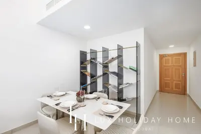 a white dining room with a white table and chairs at LUX The Armada Suite JLT in Dubai