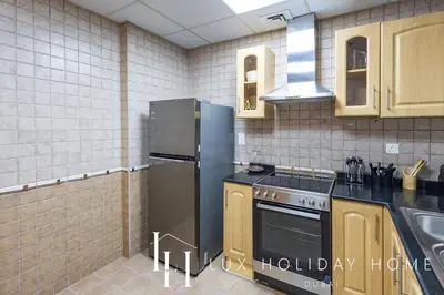 a kitchen with a stainless steel refrigerator and a sink at LUX The Armada Suite JLT in Dubai