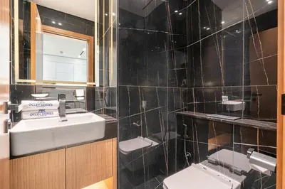 a bathroom with a sink and a toilet and a mirror at Sleek Modern Home in the Heart of JVC in Dubai