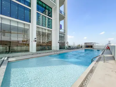 a swimming pool in front of a building at Sleek Modern Home in the Heart of JVC in Dubai