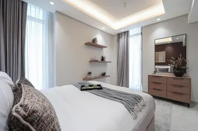 a bedroom with a white bed and a mirror at Stylish 1 BR in Cloud Tower in Dubai