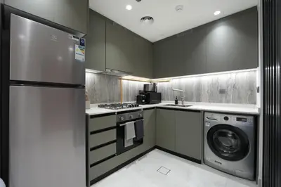 a kitchen with a refrigerator and a washer and dryer at Stylish 1 BR in Cloud Tower in Dubai