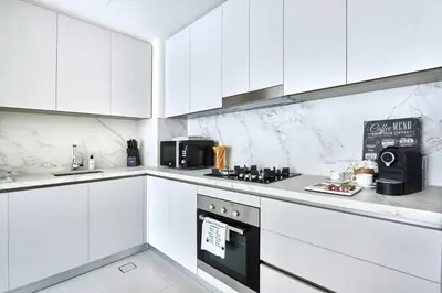 a white kitchen with white cabinets and a stove at Frank Porter - Beach Mansion in Dubai