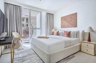 a white bedroom with a large bed and a desk at Frank Porter - Beach Mansion in Dubai