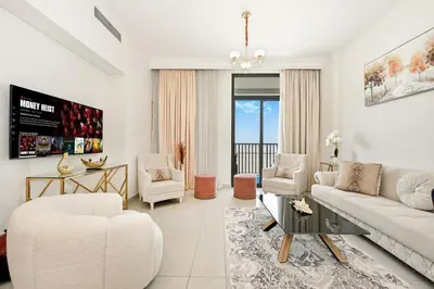 a living room with a white couch and chairs at Bloomfields Tranquil 2BR in Dania 4 in Dubai