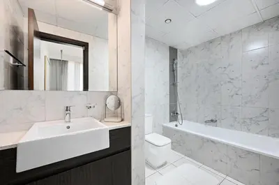 a bathroom with a sink and a toilet and a tub at Bloomfields Tranquil 2BR in Dania 4 in Dubai