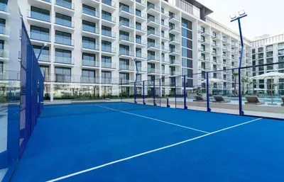 a tennis court in front of a building at Contemporary Studio with Premium Design in JVC in Dubai