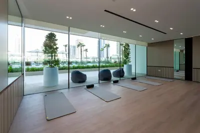 a yoga room with a lot of windows and yoga mats at Contemporary Studio with Premium Design in JVC in Dubai