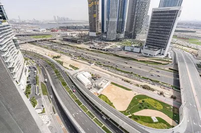 an overhead view of a highway in a city with tall buildings at Central Modern Studio with Floor to Ceiling Windows in Dubai