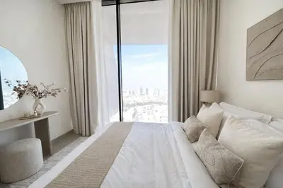 a bedroom with a white bed and a large window at Elegant 1BR Haven at Binghatti Phantom in Dubai