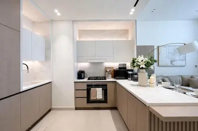 a kitchen with white cabinets and a stove top oven at Elegant 1BR Haven at Binghatti Phantom in Dubai