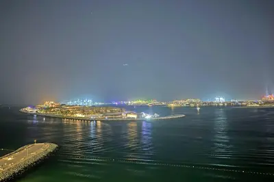a large body of water with a city at night at Miami Vibes - 1BR with Private Beach, Sea, Palm View in Dubai