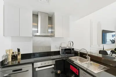 a white kitchen with a sink and a microwave at Luxury 1BR on Marina Walk, Sea & Palm View-6 Sleep in Dubai