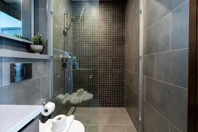 a bathroom with a glass shower with a toilet at 1BR plus Study Peaceful, Family-Friendly Community in Dubai